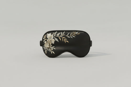 Chamomile aromatherapy sleep mask in black fabric on neutral background